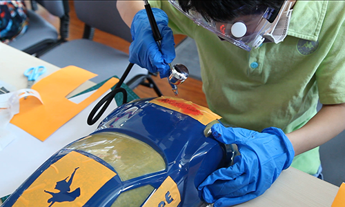 孩子在進(jìn)行汽車圖案的噴繪工序(尺寸修改).png